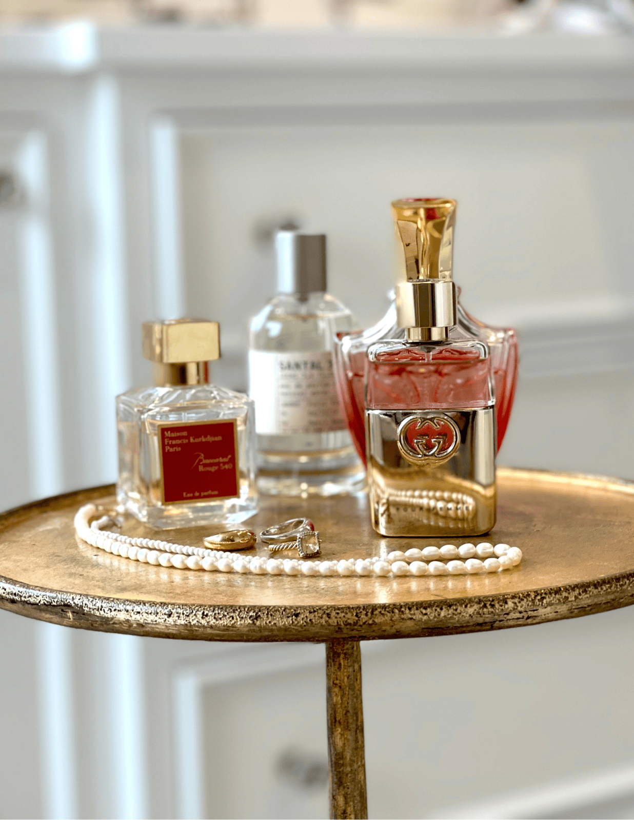 Susie's favorite fragrances displayed on gold table: Baccarat Rouge 540 | Le Labo Santal 33 | Gucci Guilty | Creed Royal Princess Oud