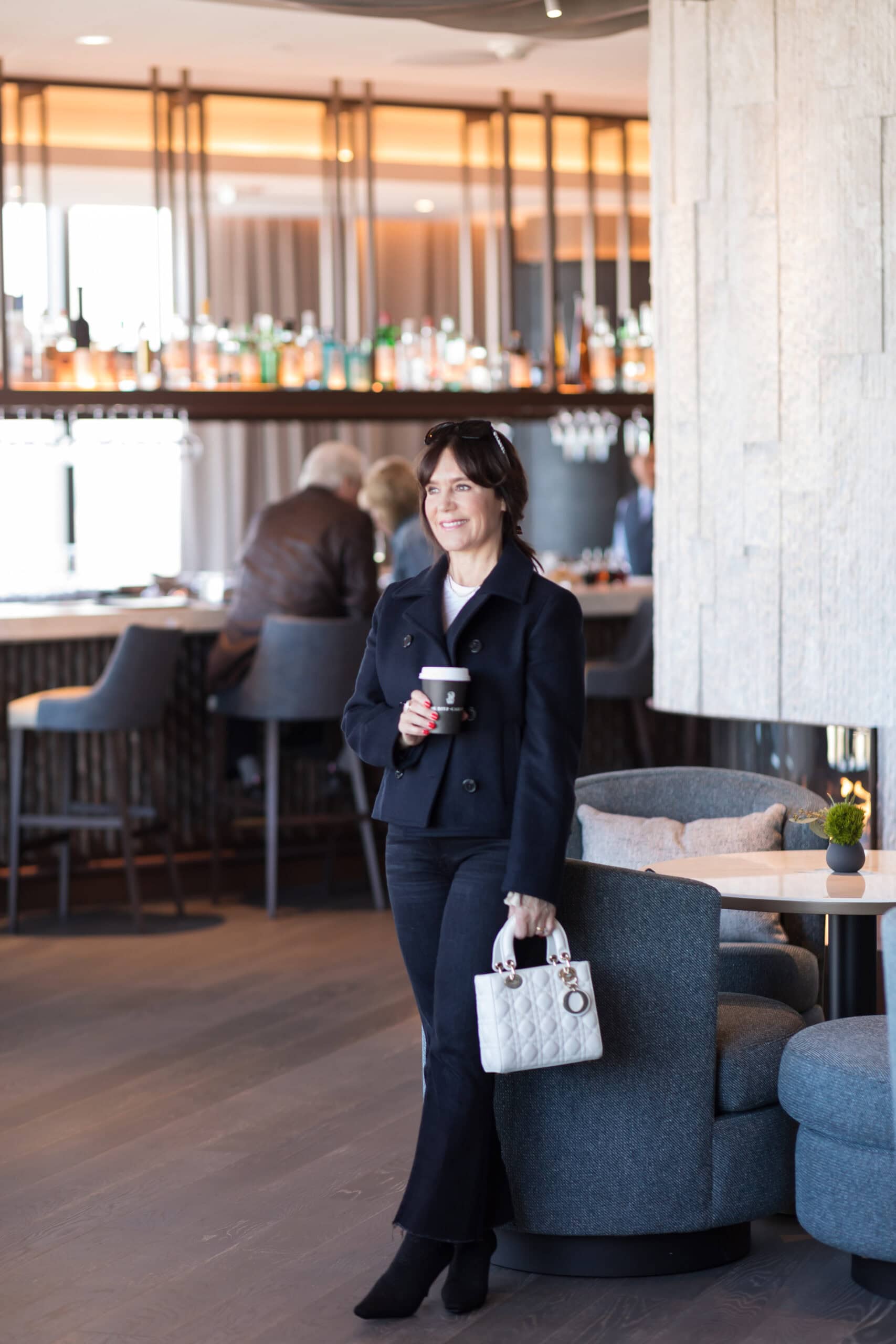 Susie at the Ritz-Carlton Portland wearing cropped trench, black jeans, and black boots. 