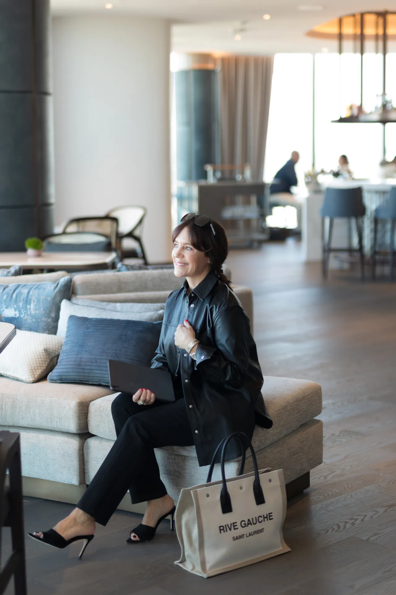 Susie at the Ritz Carlton, Portland, wearing faux leather jacket, black jeans, and black sandals. 