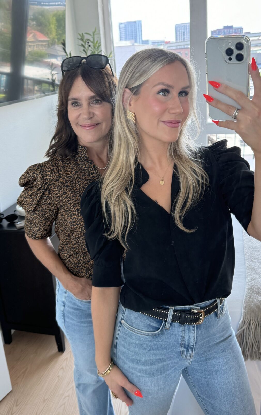 Susie (left) wearing leopard blouse and light blue jeans and daughter Emily (right) wearing black blouse, black belt with gold studs and light blue jeans.