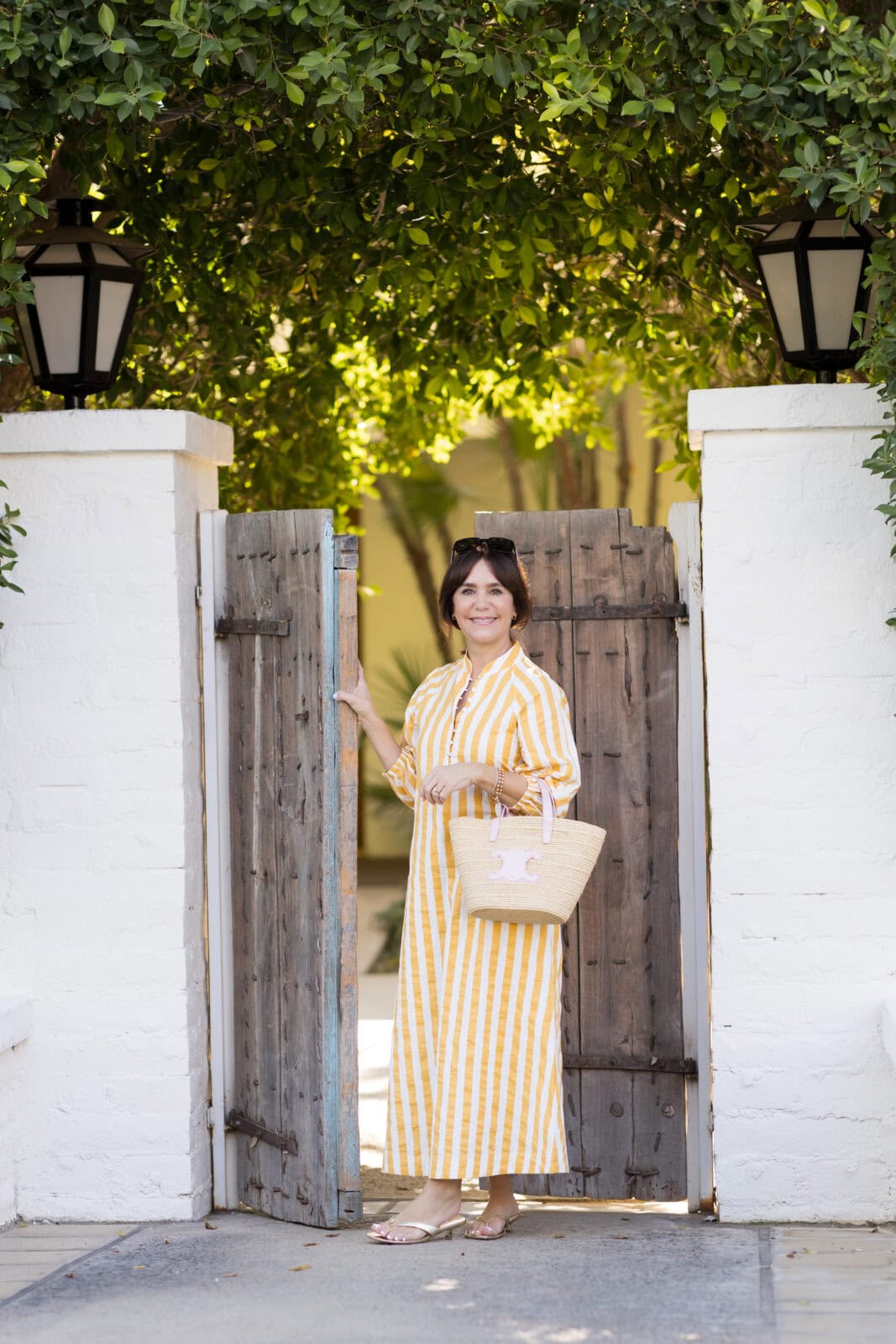 Susie in a striped yellow caftan for an effortless vacation look.