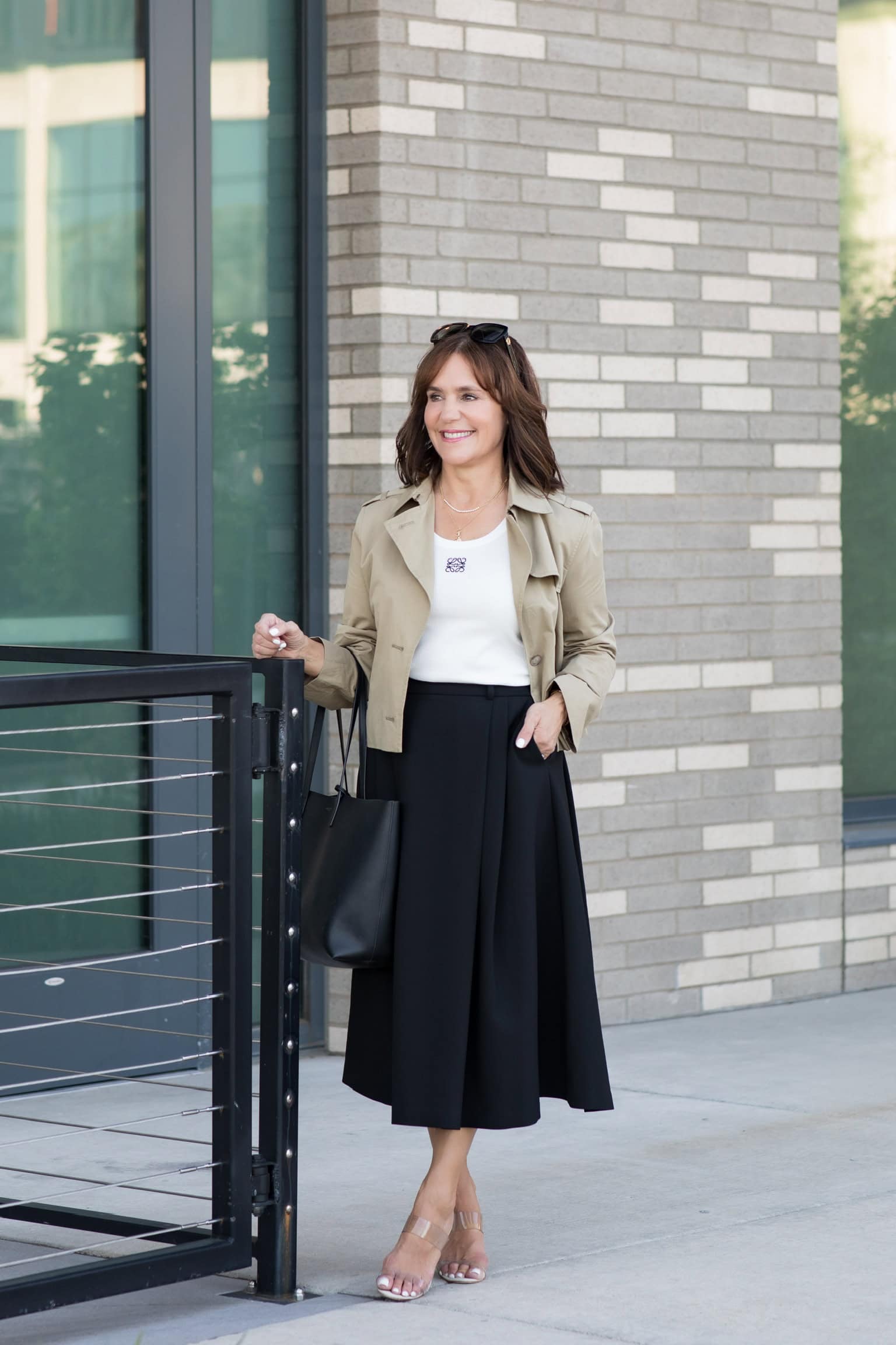 Susie wearing simple spring outfit with a cropped trench and flared midi skirt.