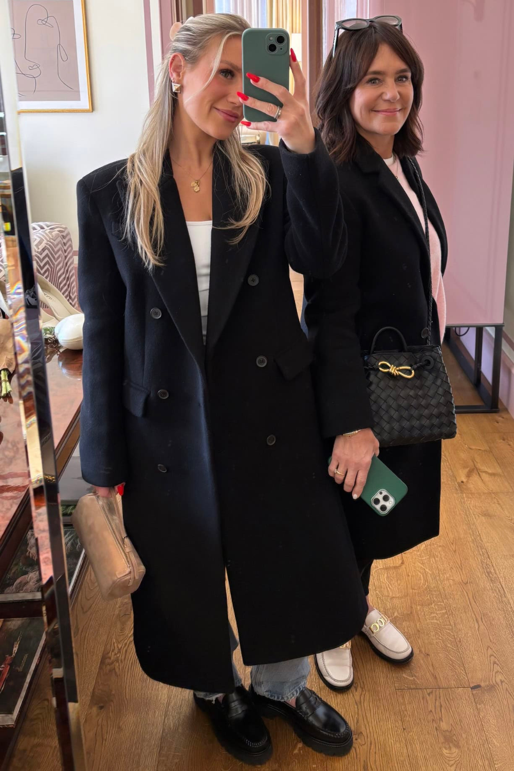 Susie and Emily shopping with black coats, leather loafers, and wide leg jeans.