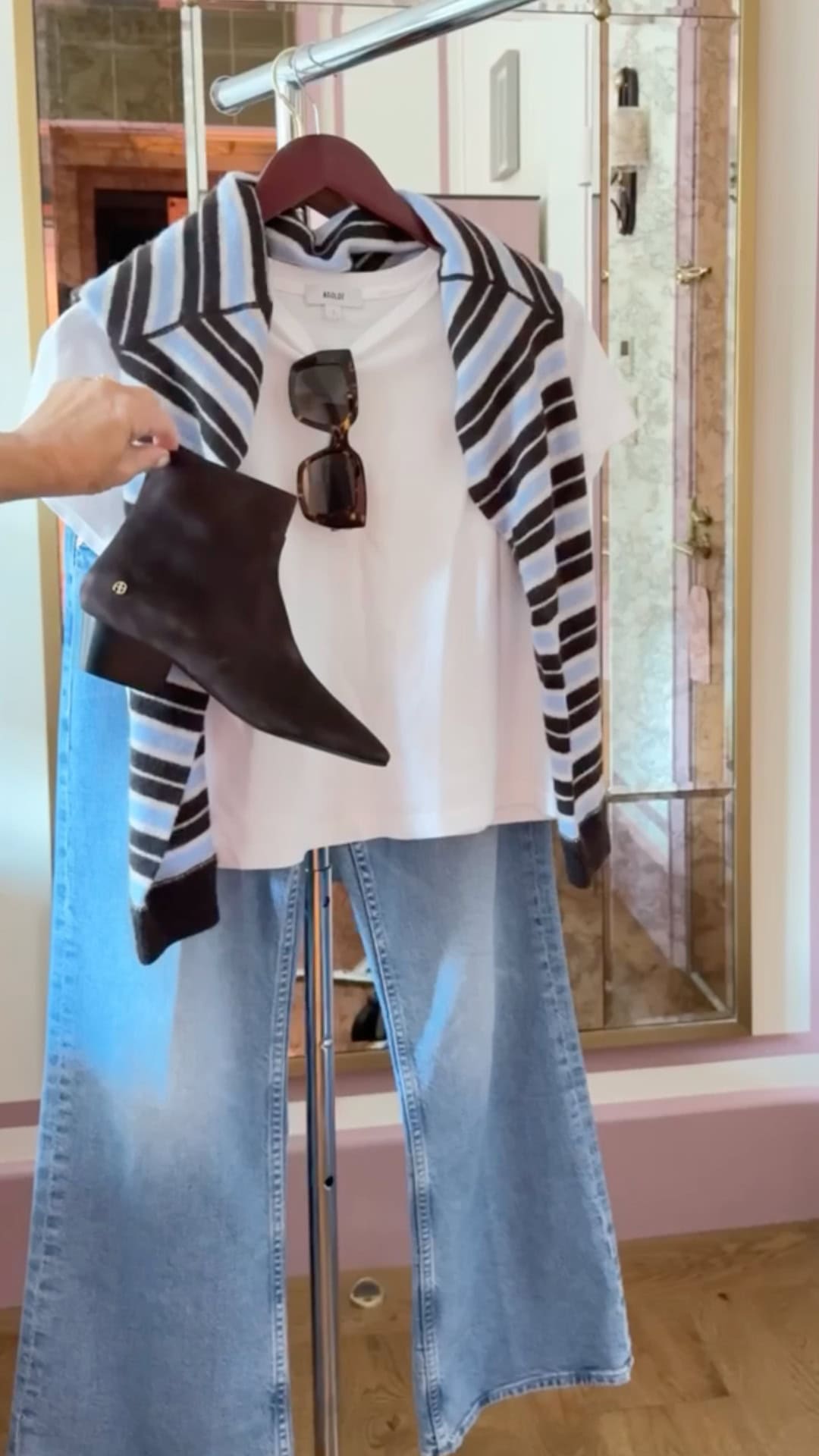 White tee shirt with light wash denim, suede booties, sunglasses, and blue and black striped sweater.